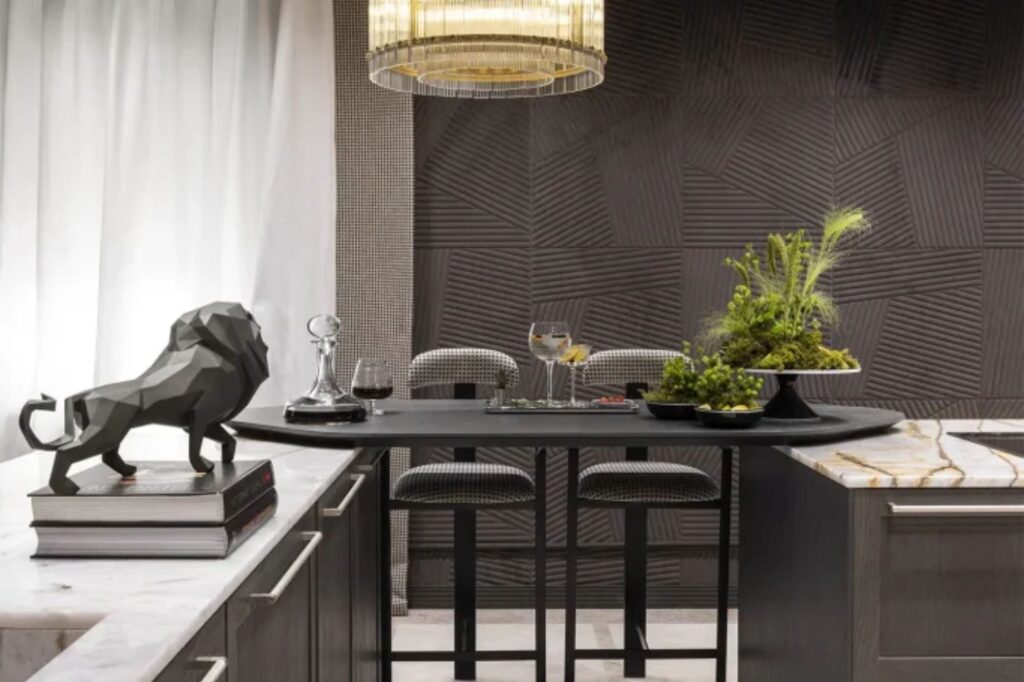 Diseño de cocinas con isla expositiva oscura, iluminación decorativa y vegetación